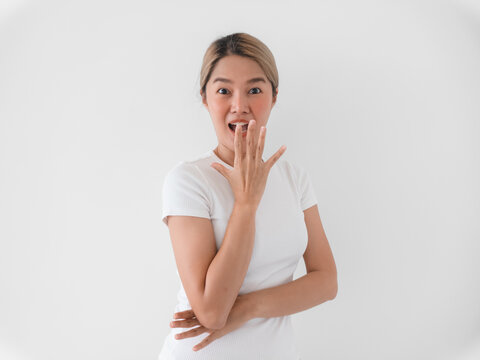 Surprised Asian woman displays shock with quiet backdrop