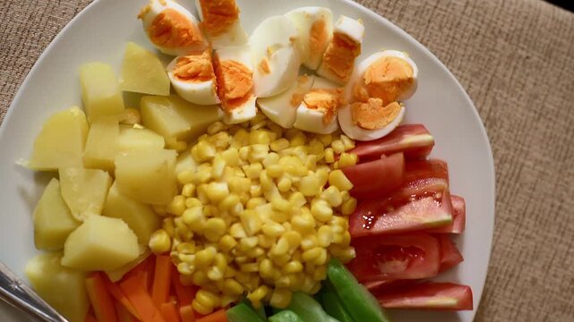Rotate handheld top view shot of healthy vegetable salad on white plate