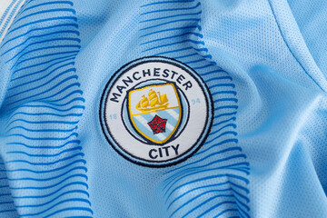 Naklejka premium Kyiv, Ukraine, May 5, 2026. Close-up of Manchester City football jersey fabric with club crest logo texture