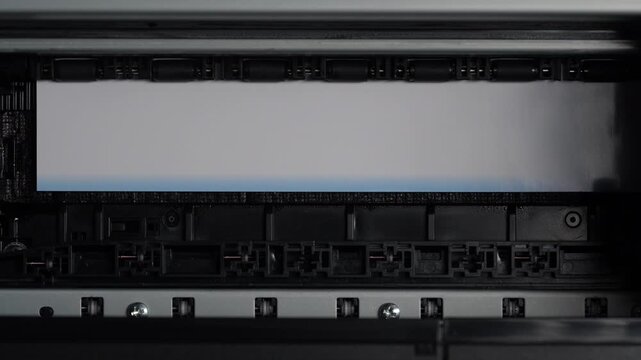 Inkjet printer printing color photo, top view. Close up of a high quality photo printer printing an image. Concept of digital photography printing service and home office
