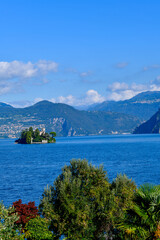 Fototapeta premium Blick über den Iseosee auf die private Insel Loreto (Isola di Loreto) mit der neugotischen Villa vor der alpinen Bergkulisse