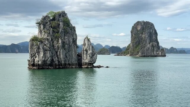 scenic limestone karst formations rising from tranquil emerald waters of ha long bay, vietnam landscape travel destination
