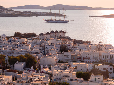 View of Chora, mills, cruise ships and sunset on the Aegean Sea on Mykonos island in Greece