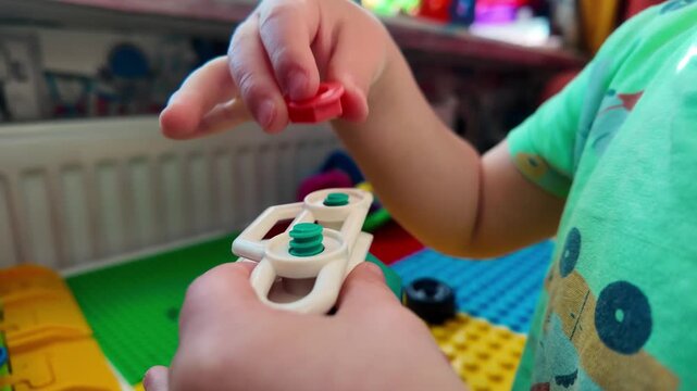Child playing toy car wheel close up kid hands turning bolt fine motor skills learning development educational play toddler activity