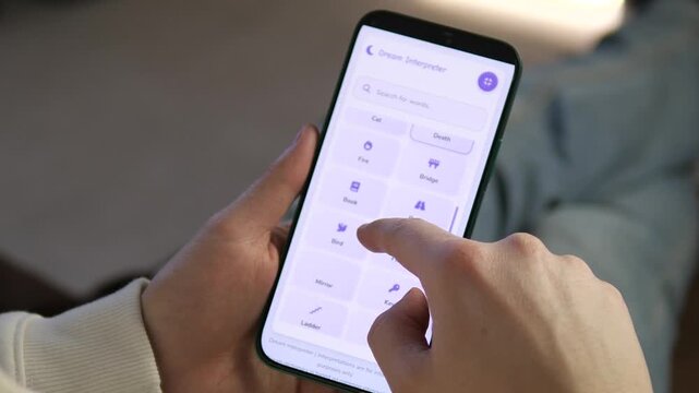 Explore the subconscious. Close-up of a person using a mobile dream interpreter app. Features a clean UI with symbols like money, snakes, and flights. Perfect for psychology, wellness, and self-care