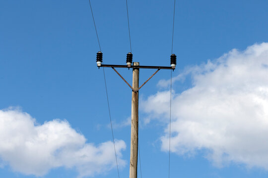 An overhead power pole carries electricity over distances, using wood, metal, or concrete structures with insulators that prevent current flow, safely delivering energy from plants to homes and busine