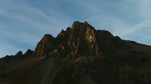 Last golden light of sunset hitting dramatic mountain peak in Swiss Alps at Maloja Pass, Switzerland