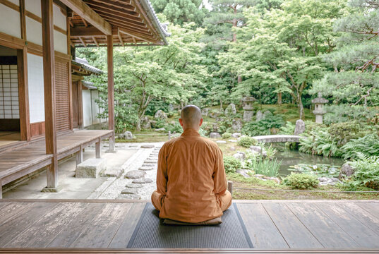 日本庭園を眺めて座禅する僧侶