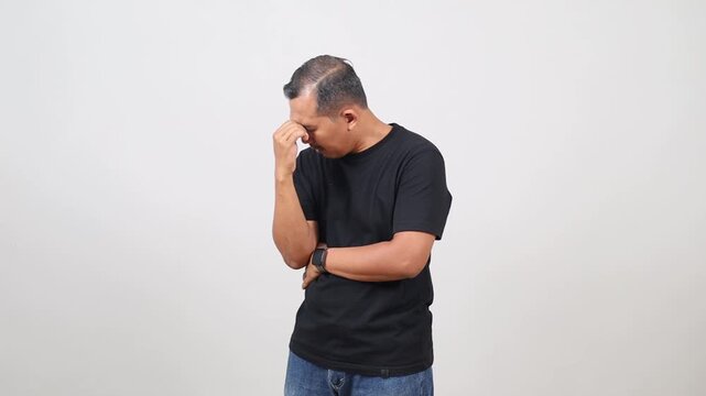 Discontent tired Asian man holding his head, has tired expression. Fatigue overworked middle age guy