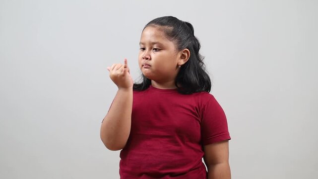 Funny Asian little girl is picking her nose using finger