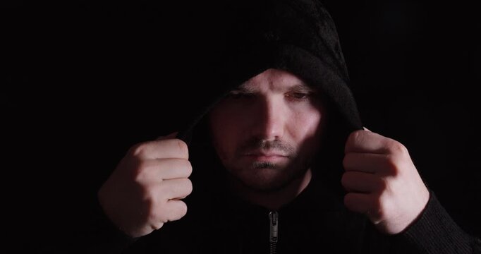 Man pulling his hood down and back, symbolizing identity, self-reflection, and inner struggle.