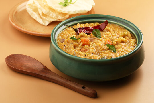 Sambar Rice - Tasty and popular south indian recipe served in a ceramic bowl with appalam or papad