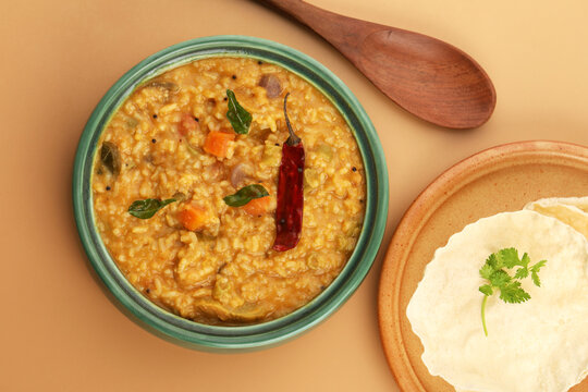 Sambar Rice - Tasty and popular south indian recipe served in a ceramic bowl with appalam or papad