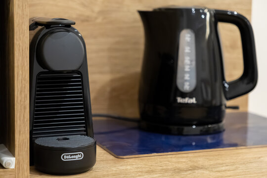 Przemysl, Poland - March 30, 2026: DeLonghi coffee machine and Tefal electric kettle on wooden kitchen counter, representing modern beverage preparation in a home appliance setup