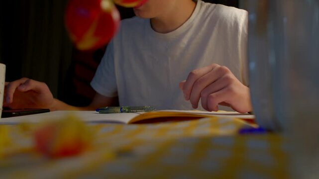 white young man assembling model, focused hands and delicate tools on checkered tablecloth, warm lamp casting soft glow, blurred foreground fruit and glass, quiet evening hobby scene, patient