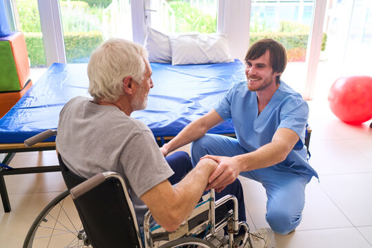 Physiotherapist Assisting Senior Patient In Wheelchair At Rehab Center Providing Support And Care During Rehabilitation Session Indoors