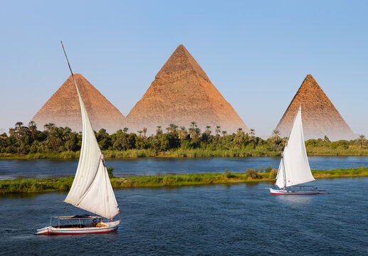 Beautiful Nile scenery with traditional Felluca sailing boat in the Nile on the way to Giza pyramids - Cairo, Egypt