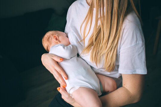 Breastfeeding concept. Portrait of a newborn baby. Mother holds a child in her arms. The first year of life. Care and health.