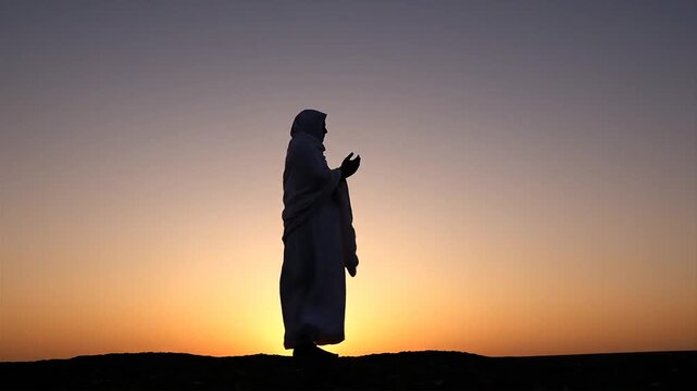 Person praying on day of Arafah at sunset in desert landscape