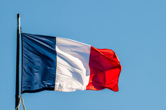 Drapeau fran&ccedil;ais en mouvement sous l'effet du vent sur fond de ciel bleu, France