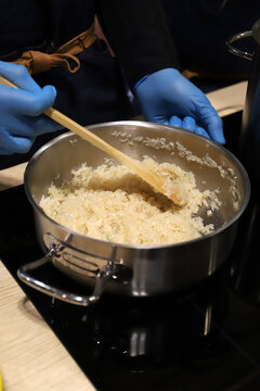 chef cocinero elaborando un guiso con arroz en una olla