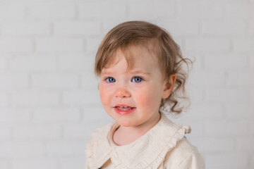 Fototapeta premium portrait of a little girl with blond curly hair and blue eyes