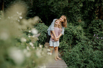 Cute child is playing with her mom in the garden. Family time.