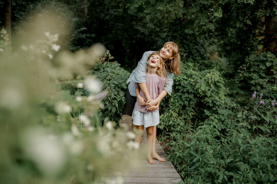 Cute child is playing with her mom in the garden. Family time.