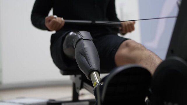 Man with prosthetic leg using rowing machine for fitness and rehabilitation