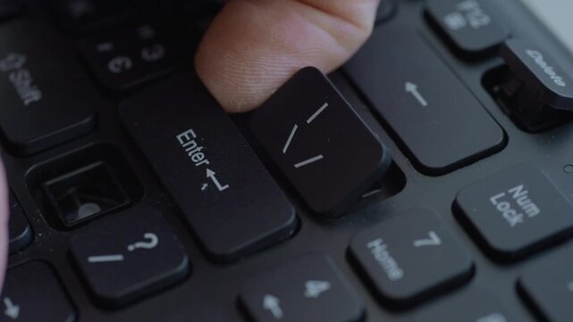Macro keyboard key removal using tool with steady hands, metal stabilizer exposed, careful lift of Enter keycap, neat office workspace, instructional repair sequence.