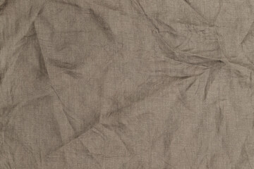 Fototapeta premium Light brown fabric with wrinkles is arranged on a flat surface in a well-lit room during the day