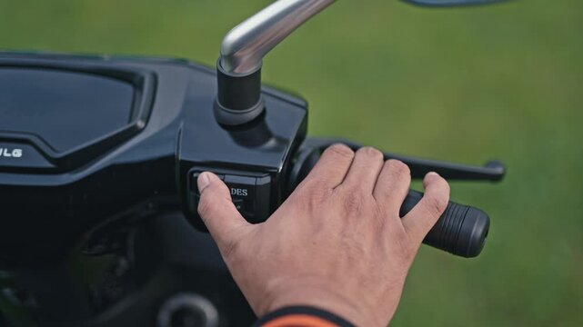 Close-up of an electric scooter power switch being turned on and off, showing control interface and user interaction in modern mobility.