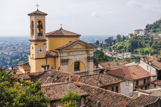 Historic Santa Grata Inter Vites church and tiled rooftops in Bergamo Citta Alta with panoramic hillside view in Italy travel destination