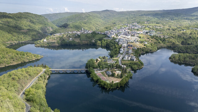 Aerial view of the historic town of Viana do Bolo situated on a peninsula surrounded by the calm waters of the reservoir and lush green hills Viana do Bolo, Province of Ourense, Spain.