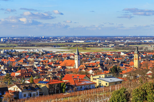 View of a town with buildings and fields under a clear sky during daytime