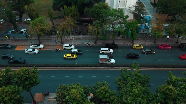 Heavy traffic congestion on urban road with cars and motorcycles timelapse, busy city street with vehicles moving in rush hour transportation, hyperlapse scene, aerial drone view 4k