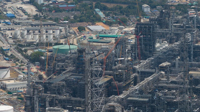 Aerial view of Bangchak Sriracha Refinery with its complex network of industrial pipes and storage tanks in Si Racha District, Chon Buri, Thailand.