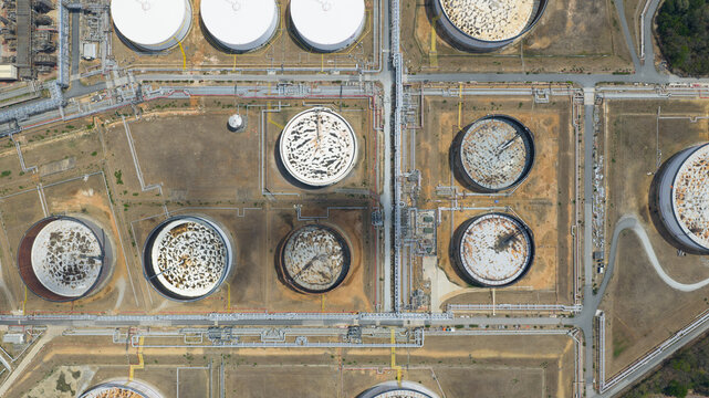 Aerial view of Bangchak Sriracha Refinery with large circular oil storage tanks and complex pipeline networks Si Racha District, Chon Buri, Thailand.