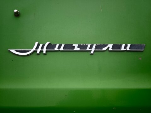 Sosnoviy Bor, Russia - April 30, 2026: Lada VAZ emblem displayed on a green car body, showcasing the brand name in a stylish metallic script, Zhiguli