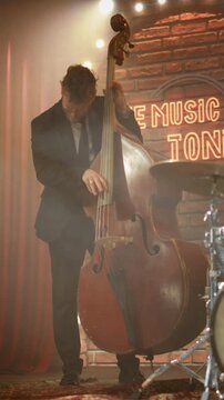 Vertical Screen. Male Double Bass Player Commands a Solo Performance With Expressive Plucking, Rhythmic Precision, and Immersive Stage Presence, Channeling Jazz Energy and Musical Emotion.