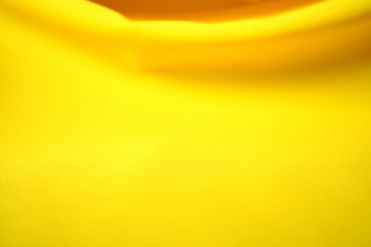 The yellow satin fabric rippled in waves.