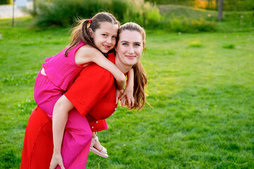 Fototapeta premium a mother and her child are walking and having fun in the park in the summer, a mother and a small child on a green lawn