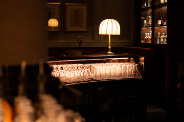 Luxury Dark Bar Interior with Warm Lamp Light and Glassware, Elegant Lounge Background with Cozy Atmosphere and Copy Space © Валентина Руденька