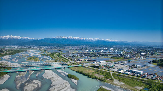 五月、田植えの季節の黒部川扇状地周辺を黒部川河口から見渡した風景