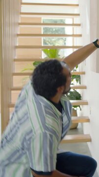 Vertical video: Measuring man in tee fixing fixture, pulling tape, marking and checking in hallway