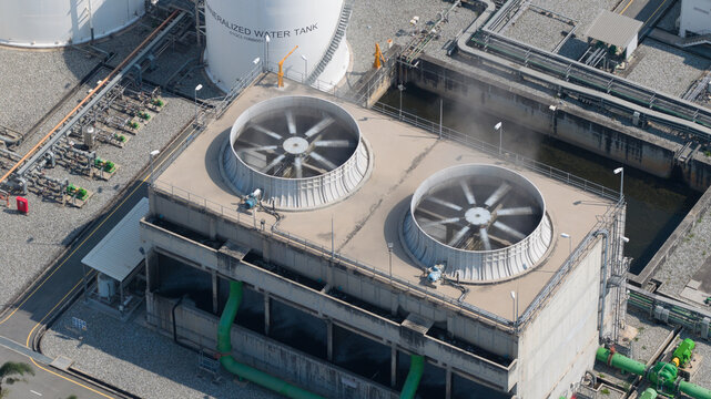 Aerial view of the cooling towers at Amata B.Grimm Power Rayong 5 with rotating fans and industrial piping in Map Yang Phon, Rayong, Thailand.