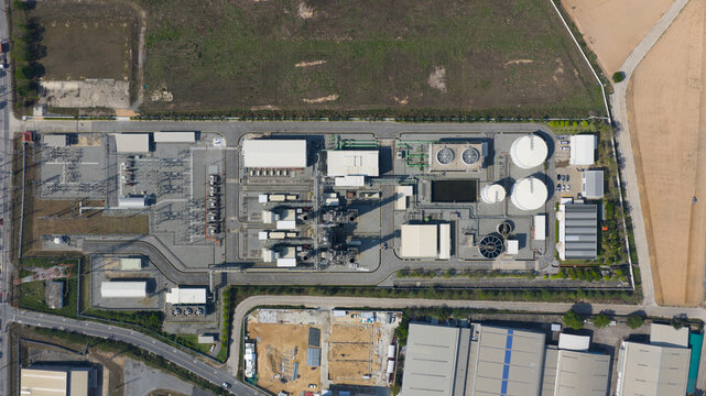Aerial view of Amata B.Grimm Power Rayong 5 industrial facility with cooling towers, storage tanks, and electrical substation in Map Yang Phon, Rayong, Thailand.