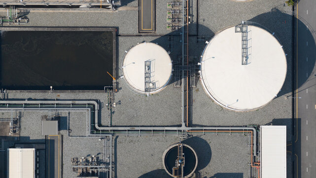 Aerial view of the Amata B.Grimm Power Rayong 5 facility featuring large white storage tanks, industrial piping systems, and water treatment basins in Map Yang Phon, Rayong, Thailand.