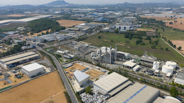 Aerial view of Amata B.Grimm Power Rayong 5 plant with industrial facilities, smokestacks, and surrounding warehouses in Map Yang Phon, Rayong, Thailand.