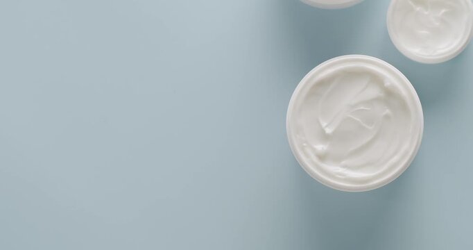 Cosmetics oils based on natural ingredients, scrub, tonic, body care. Natural cosmetics production for hair and skin care. Glossy cosmetic jar with cream. Group of different cosmetic bottles. Top view